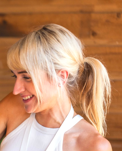 A photograph of Lauren Achtem, wearing a white sleeveless shirt. 